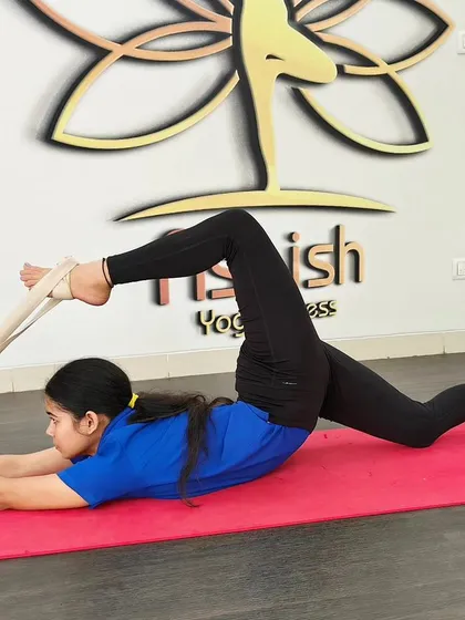 A student uses a yoga strap to work on her splits, allowing for a controlled and gradual opening of the hamstrings.