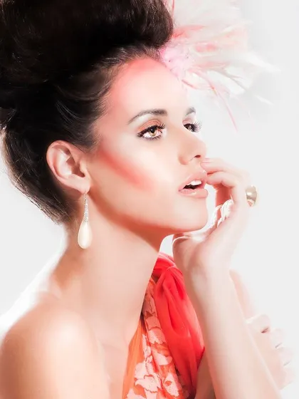 A beauty shot of the flamingo-inspired drape. The focus here is on the ombré hues and how the makeup and hair complement the draped garment to create a cohesive, high-fashion look.