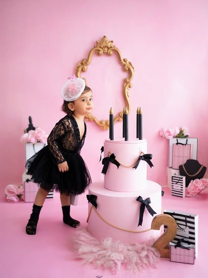 This little model has more sass at two than I've had my entire life! Her pose next to the cake in this chic pink and black setup is just iconic.