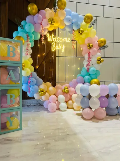 A popular and beautiful choice for welcoming your baby home. This full circular balloon arch in soft pastel colors, complete with a 'Welcome Baby' neon sign and transparent 'BABY' boxes, creates a warm and joyful atmosphere right in your living room.