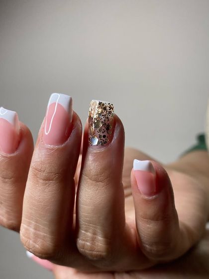 A side-swept French manicure with a glitter accent nail. This is a modern and stylish take on the classic French look.