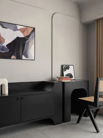 This bedroom has a retro 80s feel, with a custom-designed black bed and a matching TV and study unit. The black Chandigarh chair and abstract art complete the moody, sophisticated look.