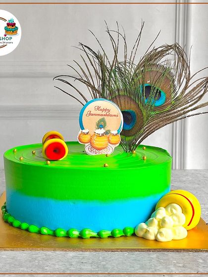 A stunning Janmashtami cake with a real peacock feather centerpiece. The vibrant colors and edible 'makhan' pot make it a perfect offering.
