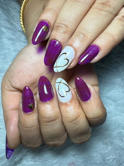 A bold and beautiful set with purple jelly nails, gold heart accents, and a white accent nail with a delicate gold heart outline.
