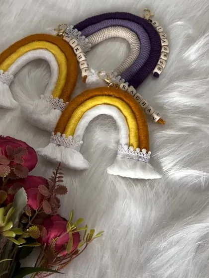 A trio of custom rainbow keychains, showcasing different color palettes from warm yellows to cool purples.