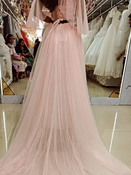 The back view of this custom pink gown shows off its beautiful long train, made from soft, dotted tulle for a touch of whimsical elegance.
