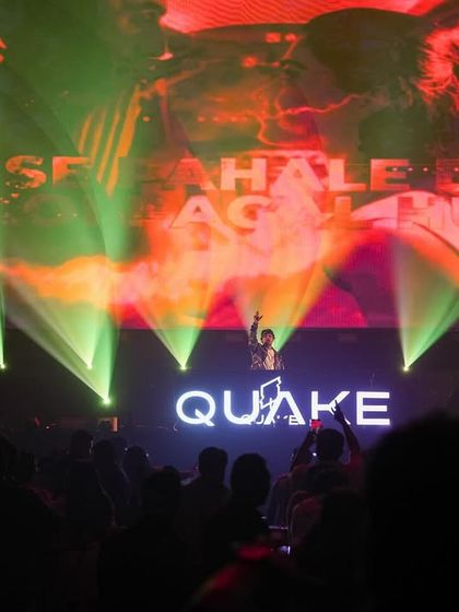 On stage at Quake, with lyrics and visuals projected onto the massive screen behind me.