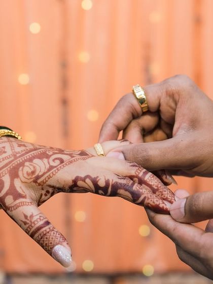 A close-up of the ring exchange, highlighting the beautiful henna and traditional bangles. We pay close attention to these significant details that are part of your engagement story.