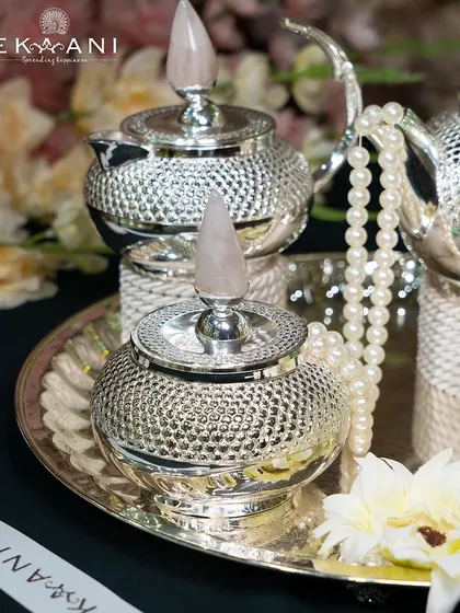 A closer view of the rose quartz tea set, highlighting the textured silver and the beautiful, natural stone accents.