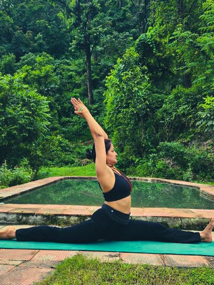 Holding Hanumanasana (Monkey Pose) in the lush greenery of Rishikesh. Nature provides the perfect backdrop for finding balance and dedication in your practice.