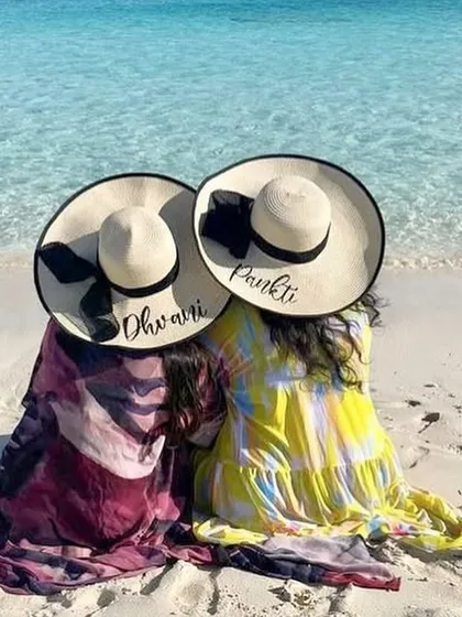 Best friends enjoying a beach day with their matching personalised sun hats. It's the perfect accessory for creating those picture perfect vacation memories.