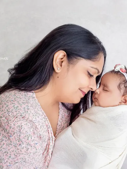 A mother gently holds her sleeping newborn, a moment of pure peace and love. These simple, clean portraits are timeless.