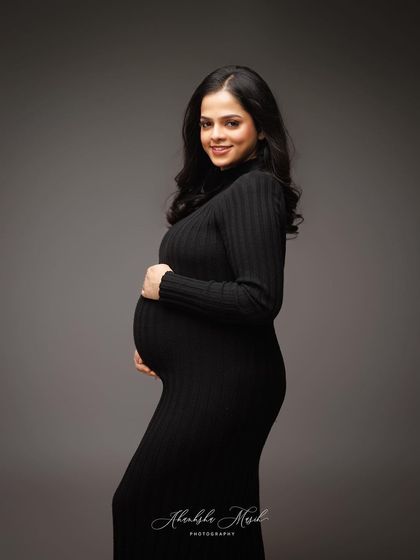 A simple black turtleneck dress can be incredibly powerful. This portrait focuses on the joyful expression and the beautiful curve of the bump, proving that elegance is in simplicity.