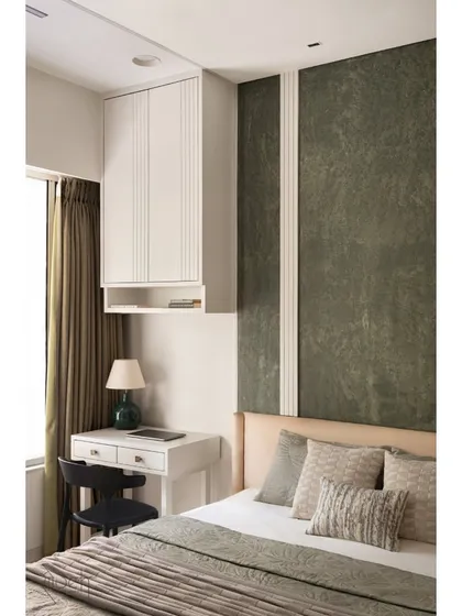 The young couple's bedroom uses a palette of olive green and white with sharp lines for a look of subtle elegance. A compact study desk is integrated next to the bed for functionality.