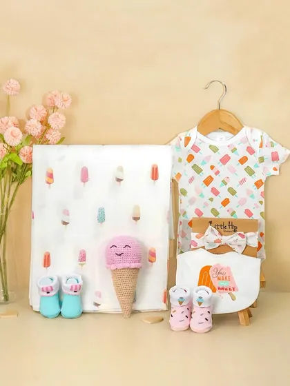 An adorable ice cream themed baby hamper. The pastel colors and cute props like the crochet ice cream cone make this a perfect shot for a girl's baby shower gift.