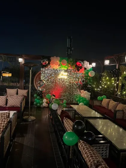 The party setup at night, with the neon sign and shimmer wall creating a vibrant focal point.