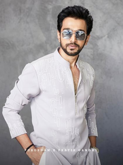 Dressed sharp, looking sharper. Pratik Gandhi owns the moment in this modern grey kurta with a zip-front and abstract white embroidery. It's a blend of elegance and attitude.