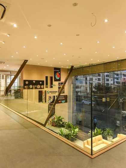 A comprehensive look at a conventional commercial space, highlighting the double-height reception, glass-walled mezzanine, and various product display areas designed for a modern business.