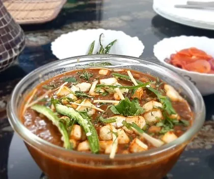 A close-up of our home-cooked chole, garnished with paneer, ginger, and green chillies for extra flavour.