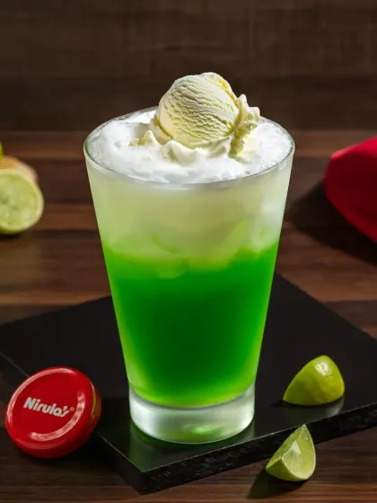 A lime-flavored ice cream soda, with its bright green color contrasting against the white foam.