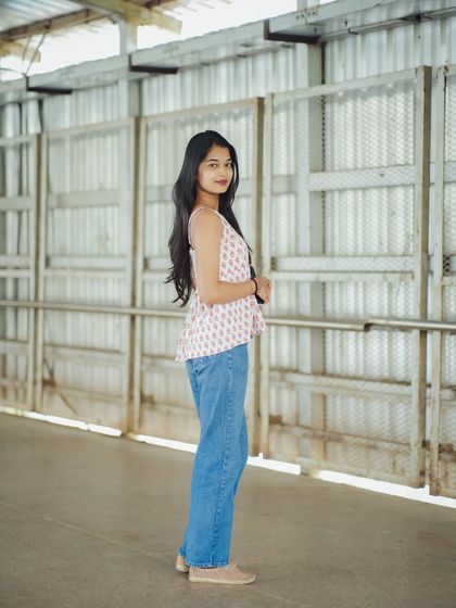 A full-length view from the same session, showing how a simple outfit can look great against an industrial background.