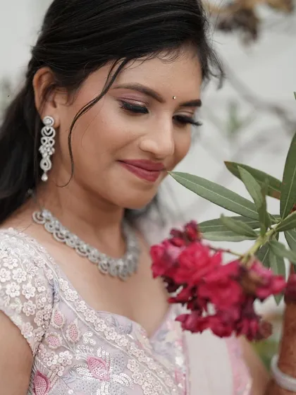 A close-up of Nisarga's soft and romantic engagement look. The focus is on flawless skin, gentle pink eyeshadow, and a natural lip color that enhances her beauty.
