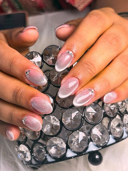 An ethereal and shimmery cat-eye effect on a sheer base, accented with tiny rhinestones at the cuticle for a touch of elegance.