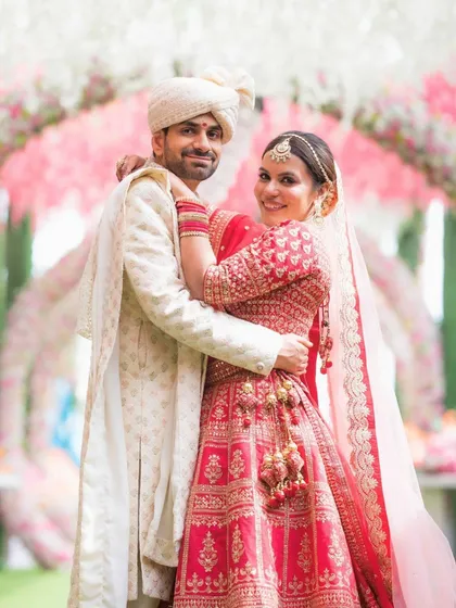 A joyful embrace between the happy couple. The bride's glowing skin and beautifully defined eyes are the stars of her luxury bridal look.