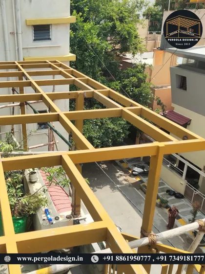A work-in-progress shot of a yellow steel pergola frame being installed on a balcony. This shows how we can add functional outdoor space even in tighter areas.