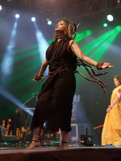 A graceful pose from a student performer, with green lighting creating a mystical feel. This shot captures the artistic expression of the students.