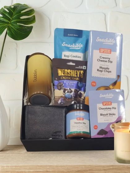 A modern and stylish Rakhi hamper for a brother, featuring a Dubblin mug, a wallet, and an assortment of premium snacks from Hershey's and Snackible.