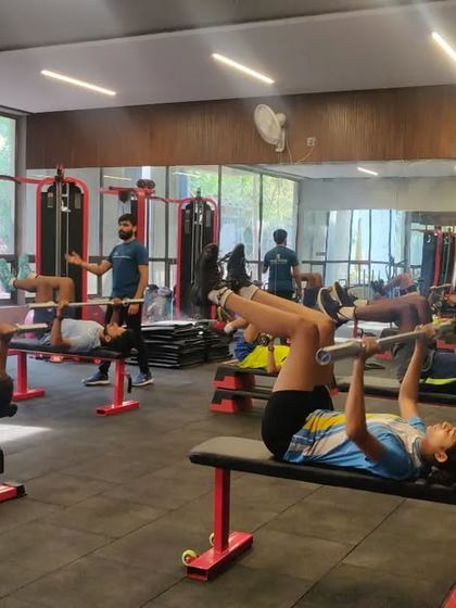A busy gym session with young athletes working on various strength exercises, including the bench press. Supervised strength training helps them develop power safely and effectively.