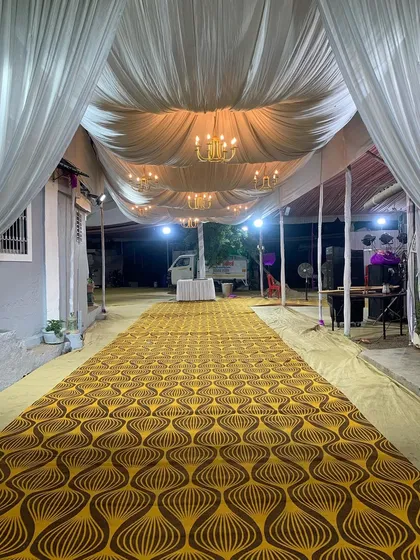A view of the long walkway we prepared for an event. The space is transformed with a patterned carpet and a fully draped ceiling with beautiful chandeliers, ready for the guests to arrive.