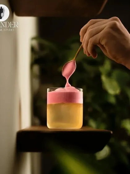 Cocktails are a canvas, and mixologists are the artists. Here, a vibrant pink foam is carefully layered onto a drink, creating a beautiful contrast.