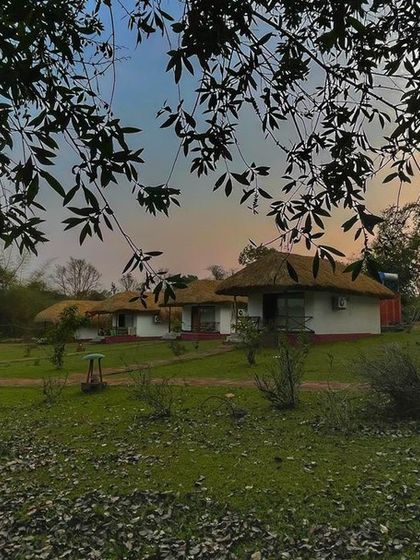 A view of the cottages at Lacuna Eco-stay at dusk, set in a serene landscape perfect for a quiet and rejuvenating holiday.