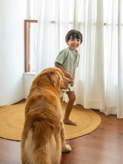 That fleeting smile you can't plan for. After a bit of playtime, Sumer flashes a joyful, genuine grin at his best pal Ziggy. My goal is to capture these real, unposed expressions that show the true connection between kids and their dogs.