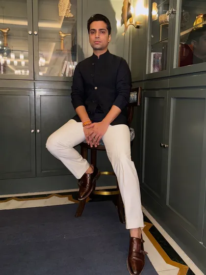 A full-length portrait. This classic look with a bandhgala jacket and white trousers is perfect for an elegant daytime event or a sophisticated evening gala.