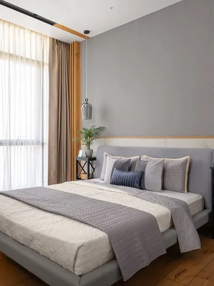 This master bedroom combines warmth and texture with wooden flooring and a raw brick side wall. To make the space feel cozier, I incorporated wooden batten panelling on the ceiling and ceiling-hung side lights for a modern, layered look.