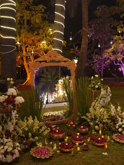An ornate gold mirror placed in the garden adds a touch of vintage glamour. It serves as a unique decor piece and a fantastic photo opportunity, reflecting the beauty of the surroundings.