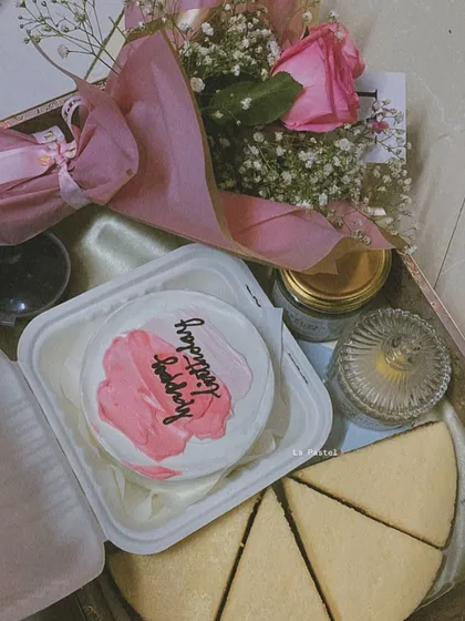This pink-themed hamper is a dream. It includes a custom bento cake, slices of my classic cheesecake, scented candles, and a bouquet of pink roses.