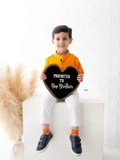 The best promotion ever! This little guy is so excited to announce he's been "Promoted to Big Brother" in this adorable announcement photoshoot.