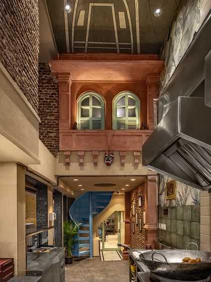 A view from the kitchen of Shiv Mishthan Bhandar, looking up at the interior jharokha and painted ceiling. This perspective shows the verticality and rich detailing of the design.