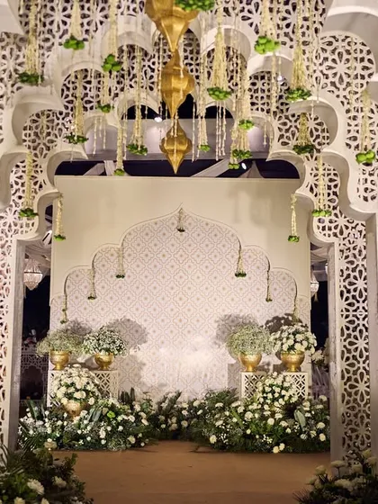 This entrance for a 'Noor-e-Ishq' Sufi night captures the essence of Mughal grandeur. The intricate white jaali arches, adorned with delicate floral strings and brass lanterns, created a poetic and royal welcome for guests, transporting them to a world of timeless romance.