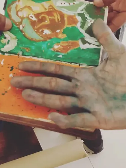 A candid shot of my paint-stained hands holding my palette. This is the reality of an artist's 'kaam' (work).