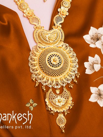 A magnificent long necklace with a large, circular pendant, showcasing our expertise in creating grand, statement pieces for bridal wear. The intricate filigree work is a testament to our craftsmanship.