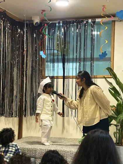 A young performer, dressed for Children's Day, confidently addresses the audience. We provide the stage and the microphone to help every child's voice be heard.