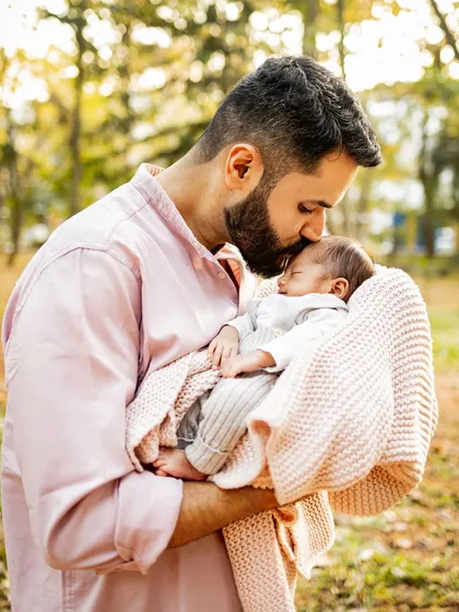 A father's gentle kiss for his newborn son during the magical golden hour. These are the fleeting, tender moments I live to capture, telling the story of your family's love.