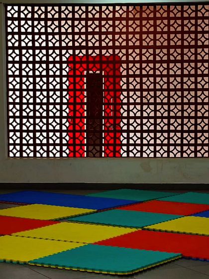 A playspace featuring a decorative jali screen. The pattern of the screen casts interesting shadows and provides ventilation while maintaining a sense of enclosure.