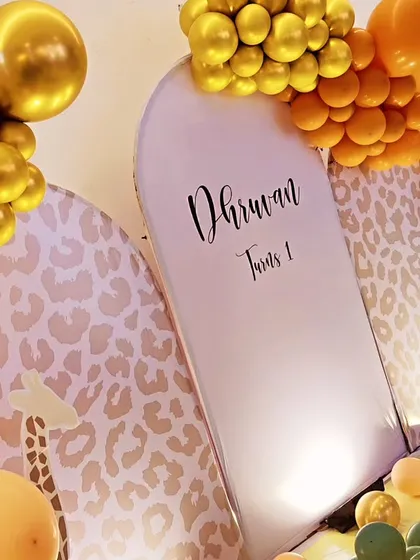 A detailed shot of our jungle theme, focusing on the leopard-print backdrop panels and the rich, textured balloon clusters in orange and green.