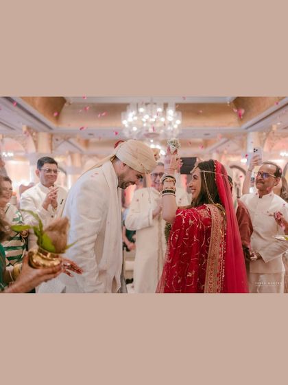 A candid moment during the wedding ceremony. The bride's playful gesture and the groom's smile show the friendship and love that underpins their marriage.